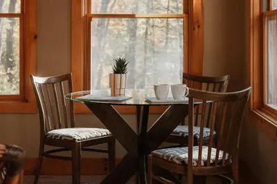 a table with two chairs and a table with a plant on it at Tuthill Treehouse - Secluded Mountain Cabin with Roof Deck & Fire Pit in Pond Eddy