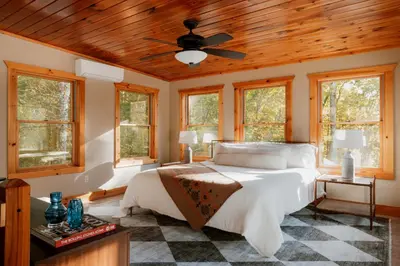 a bedroom with a bed with a wooden ceiling at Tuthill Treehouse - Secluded Mountain Cabin with Roof Deck & Fire Pit in Pond Eddy