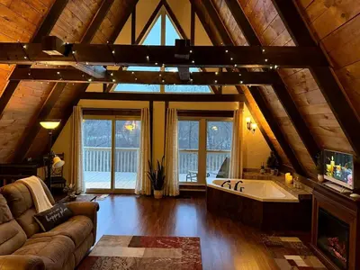 a large living room with a large tub in a cabin at Fantastic A-Frame Cabin for a Couples' Getaway near Robesonia, Pennsylvania in Robesonia
