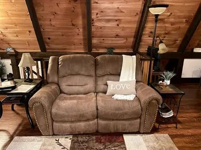 a living room with a brown couch with a love pillow on it at Fantastic A-Frame Cabin for a Couples' Getaway near Robesonia, Pennsylvania in Robesonia