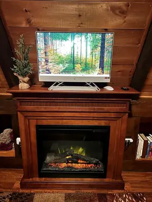 a computer monitor sitting on top of a fireplace at Fantastic A-Frame Cabin for a Couples' Getaway near Robesonia, Pennsylvania in Robesonia