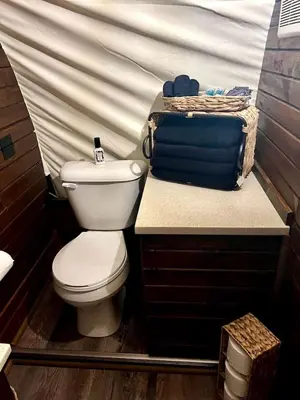 a bathroom with a toilet and a table with a tent at Elegant, Vintage Conestoga Covered Wagon Getaway in Denver, Pennsylvania in Denver