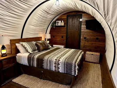 a bedroom with a bed in a tent at Elegant, Vintage Conestoga Covered Wagon Getaway in Denver, Pennsylvania in Denver
