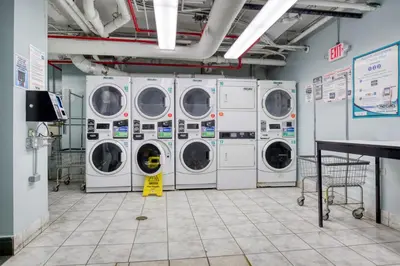 a laundry room with four washing machines in it at Blueground Upper West Side fitness nr Central Park NYC-1932 in New York