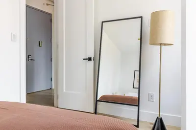 a mirror in a bedroom with a bed and a lamp at Blueground Midtown West washerdryer nr Central Park NYC-1876 in New York