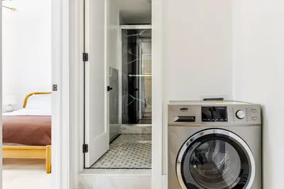 a washer and dryer in a room with a bedroom at Blueground Midtown West washerdryer nr Central Park NYC-1876 in New York