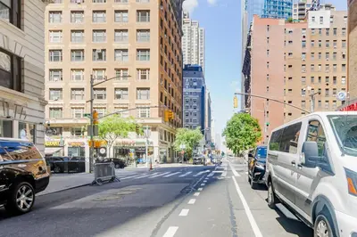 a city street with cars parked on the street at Blueground Midtown West washerdryer nr Central Park NYC-1876 in New York