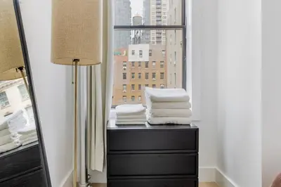 a room with a window with a pile of towels at Blueground Midtown West washerdryer nr Central Park NYC-1876 in New York