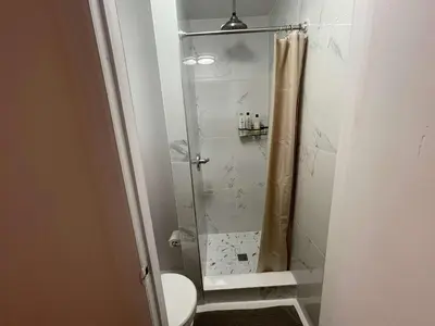 a bathroom with a glass shower with a toilet at Renovated Studio in Union Square in New York