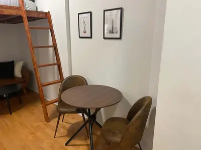 a table and chairs in a room with a ladder at Renovated Studio in Union Square in New York