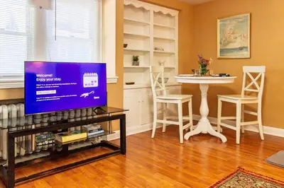 a living room with a tv and a table at Comfy 1 BR Hide Away Apt w Garage Parking in Bryn Mawr