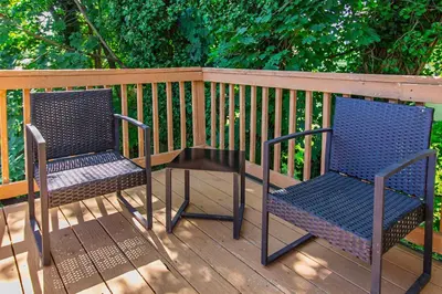 two chairs and a table on a wooden deck at Comfy 1 BR Hide Away Apt w Garage Parking in Bryn Mawr