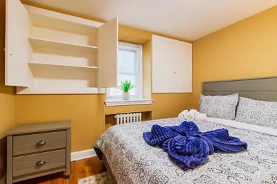 a bedroom with a bed with a purple blanket on it at Comfy 1 BR Hide Away Apt w Garage Parking in Bryn Mawr