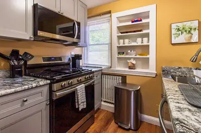a kitchen with a stove and a microwave at Comfy 1 BR Hide Away Apt w Garage Parking in Bryn Mawr