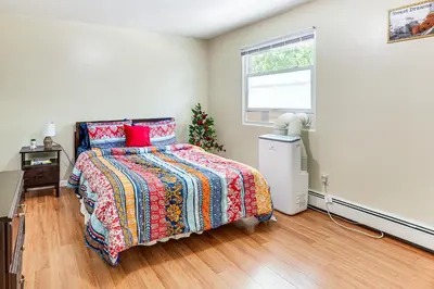 a bedroom with a bed with a colorful bedspread and a window at 2 Mi to The Marketplace Spring Valley Apartment in Spring Valley
