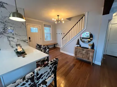a living room with a staircase and a table and chairs at Cozy Cabin On the Lake with HotTub in Hopatcong