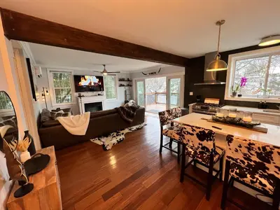 a living room with a couch and a table at Cozy Cabin On the Lake with HotTub in Hopatcong