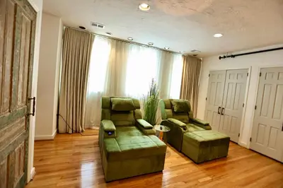 a living room with two green chairs and a couch at Urban Luxe Redefined in Central city Phila in Philadelphia