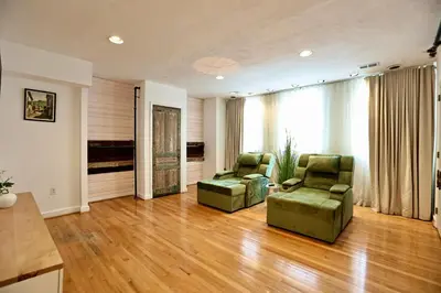a living room with two green chairs and a large window at Urban Luxe Redefined in Central city Phila in Philadelphia
