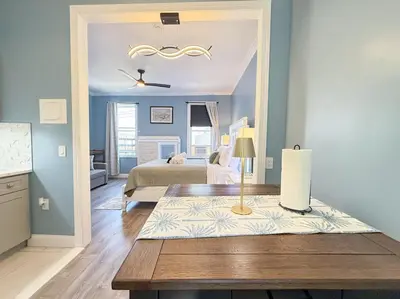 a bedroom with a bed and a table in a room at New York City Dreams - 10 Mins in Union City