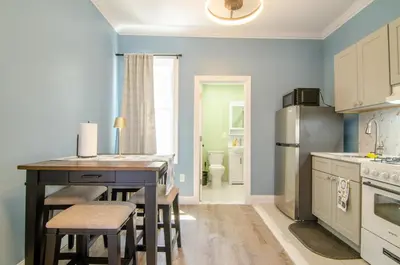 a kitchen with a table and chairs and a refrigerator at New York City Dreams - 10 Mins in Union City