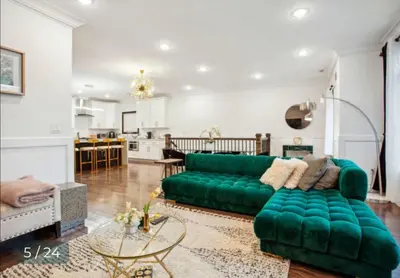 a living room with a green couch and a kitchen at Contemporary Luxury 3 Bdr Apt for 6 with Free Parking in Jersey City