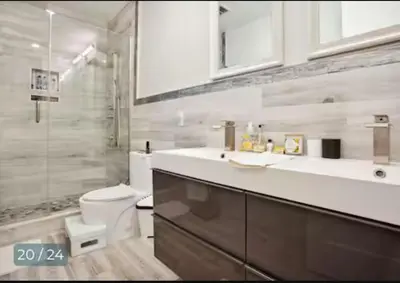 a bathroom with a toilet and a sink and a shower at Contemporary Luxury 3 Bdr Apt for 6 with Free Parking in Jersey City
