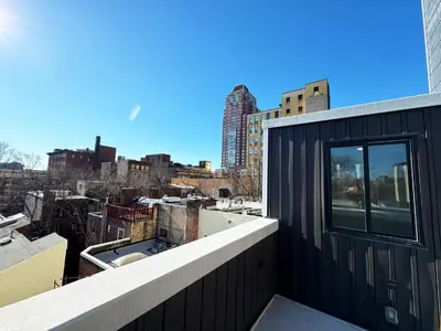 a black building with a window on top of a city at The Executive - Center-City - 3BR-4Bath-Private-Garage in Philadelphia