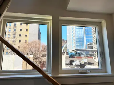 two windows in a stairwell with a view of a city at The Executive - Center-City - 3BR-4Bath-Private-Garage in Philadelphia