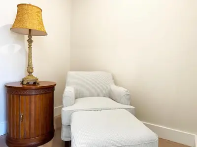 a room with a chair and a lamp and a stool at The Executive - Center-City - 3BR-4Bath-Private-Garage in Philadelphia