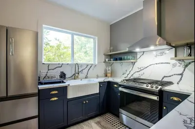 a kitchen with blue cabinets and a sink and a window at Cozy Cottage on a Private Farm Nestled Among the Southern Catskill Mountains in Woodridge, New York in Woodridge