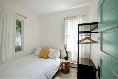 a bedroom with a white bed and a window at Cozy Cottage on a Private Farm Nestled Among the Southern Catskill Mountains in Woodridge, New York in Woodridge