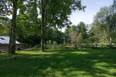 a yard with a fence and a tree with a hammock at Cozy Unique Dome for a Romantic Glamping Getaway on a Private Farm in Woodridge, New York in Woodridge