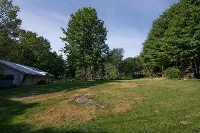 an empty yard with a house and trees at Cozy Unique Dome for a Romantic Glamping Getaway on a Private Farm in Woodridge, New York in Woodridge