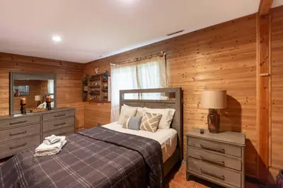 a bedroom with a bed and a dresser and a mirror at Cozy Loft Near Lake Trails and Mountain Views in Vernon Township