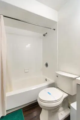 a white bathroom with a toilet and a bath tub at Cozy Loft Near Lake Trails and Mountain Views in Vernon Township