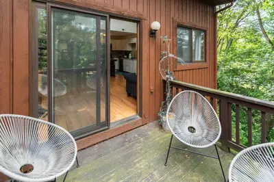 a porch with two white chairs and a house at Cozy Loft Near Lake Trails and Mountain Views in Vernon Township
