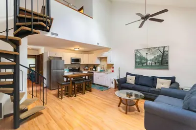 a living room with a blue couch and a kitchen at Cozy Loft Near Lake Trails and Mountain Views in Vernon Township