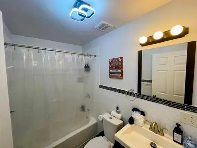a bathroom with a shower and a toilet and a sink at Cozy 2BR Brick Haven! Near light rail! 35m to NYC in Jersey City
