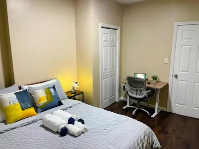 a bedroom with a bed with a teddy bear on it at Cozy 2BR Brick Haven! Near light rail! 35m to NYC in Jersey City