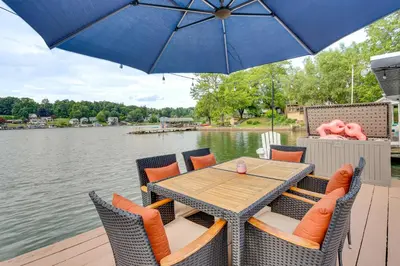 a wooden table and chairs with an umbrella on a dock at Recently Renovated Harveys Lake Retreat with Dock! in Harveys Lake