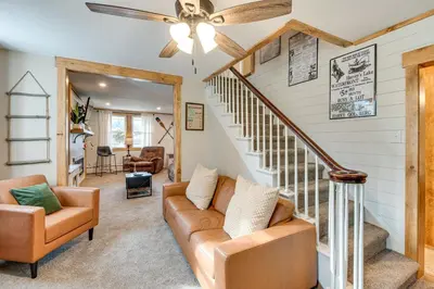 a living room with a ceiling fan and stairs at Recently Renovated Harveys Lake Retreat with Dock! in Harveys Lake