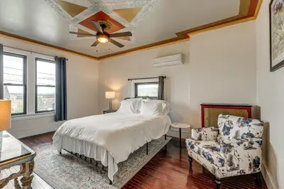 a bedroom with a bed and a ceiling fan and a chair at Near Downtown Scranton Getaway with Patio in Scranton