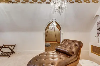 a living room with a leather chair and a chandelier at Near Downtown Scranton Getaway with Patio in Scranton
