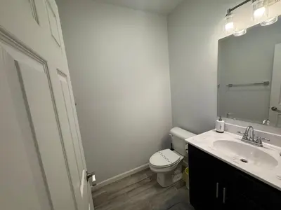 a bathroom with a sink and a toilet and a mirror at Escape to Luxury in the Poconos Your Year-Round Family Retreat in Daleville