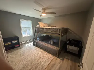 a bedroom with a bunk bed and a ceiling fan at Escape to Luxury in the Poconos Your Year-Round Family Retreat in Daleville