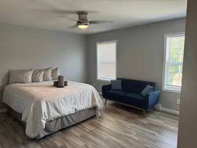 a bedroom with a bed and a blue chair at Escape to Luxury in the Poconos Your Year-Round Family Retreat in Daleville
