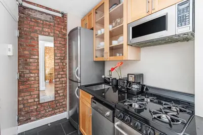 a kitchen with a stove and a refrigerator at Studio Nolita in New York