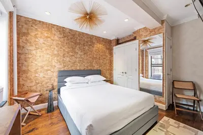 a bedroom with a large bed and a mirror at Studio Nolita in New York