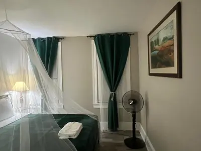 a bedroom with a green bed and a window at Little France Alsace in Phillipsburg